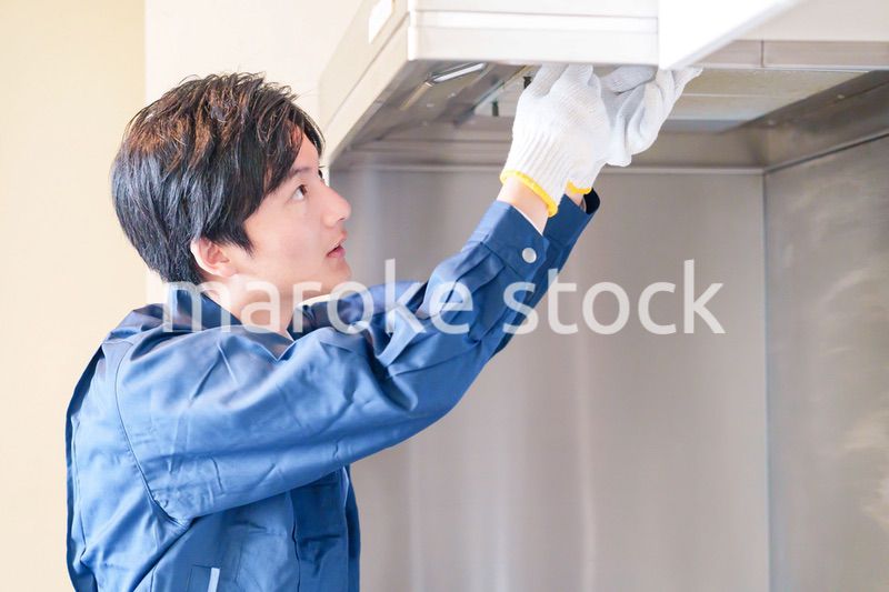 レンジフードのクリーニングをする男性の作業員