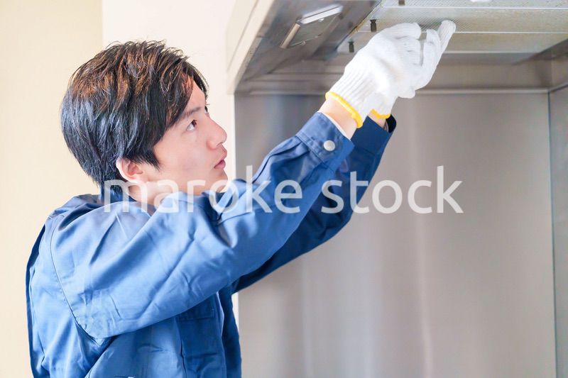 レンジフードのクリーニングをする男性の作業員