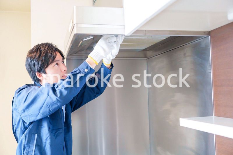 レンジフードのクリーニングをする男性の作業員