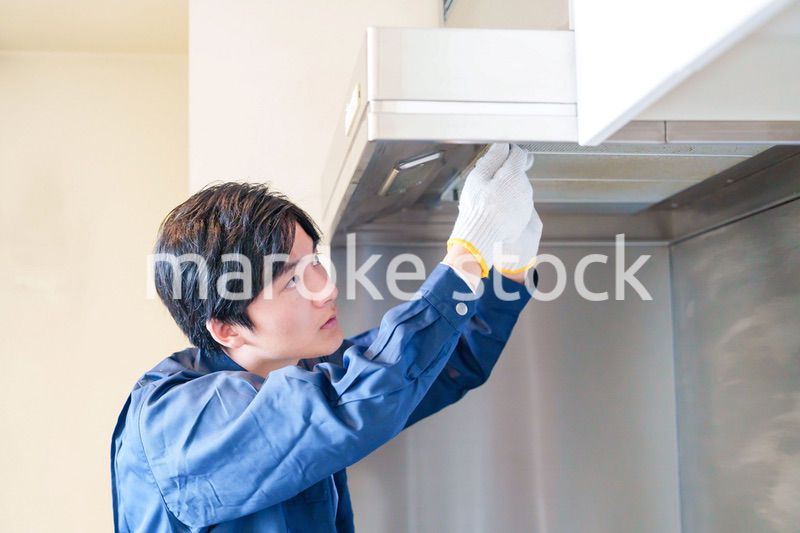 レンジフードのクリーニングをする男性の作業員