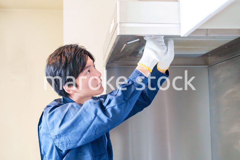 レンジフードのクリーニングをする男性の作業員