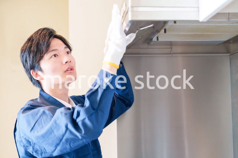 レンジフードのクリーニングをする男性の作業員