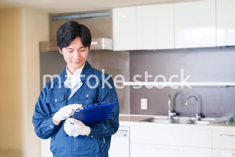 誠実な雰囲気でマンションの点検をする男性の作業員