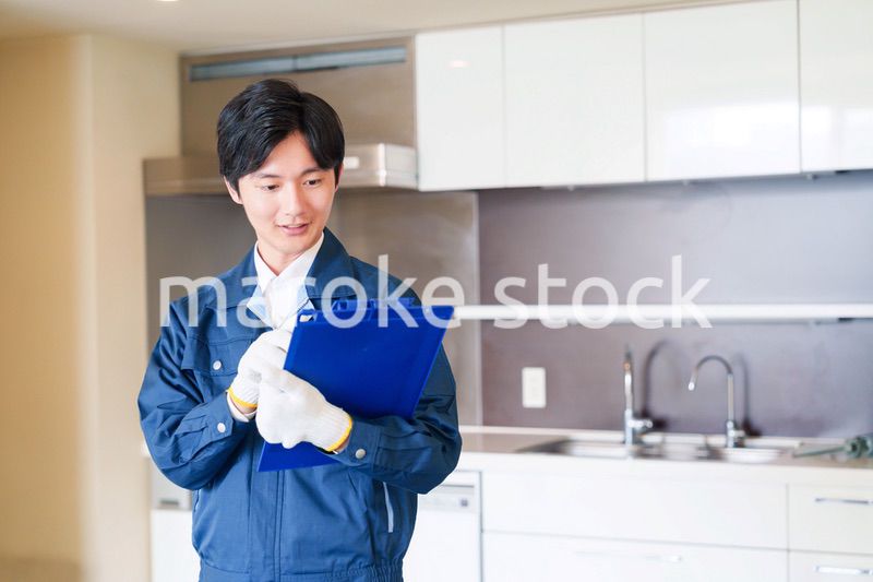 誠実な雰囲気でマンションの点検をする男性の作業員