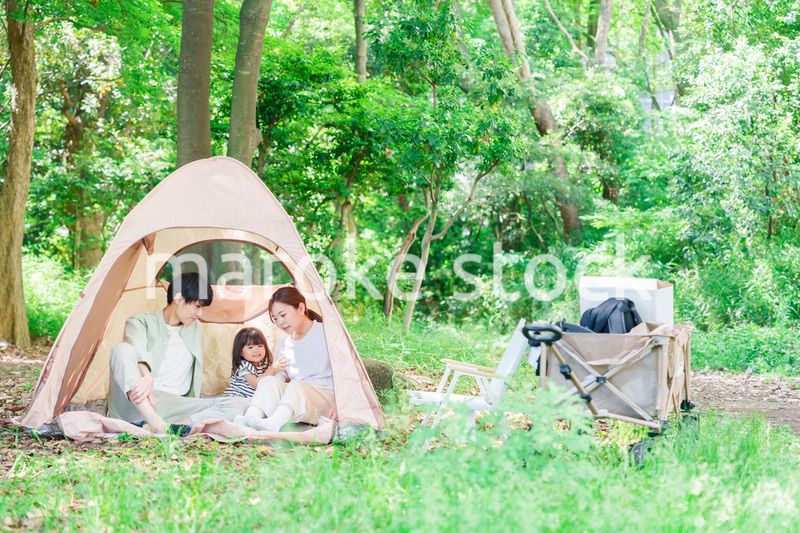 森の中でキャンプを楽しむ子供連れのファミリー