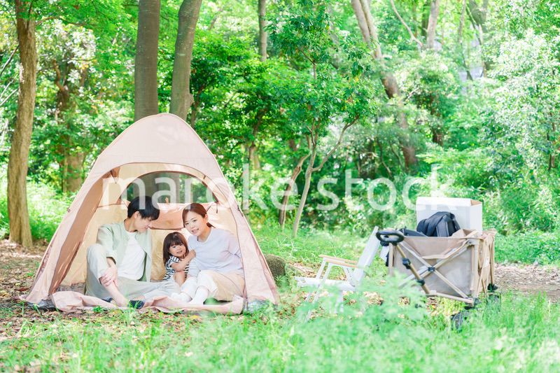 森の中でキャンプを楽しむ子供連れのファミリー
