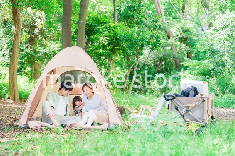 森の中でキャンプを楽しむ子供連れのファミリー