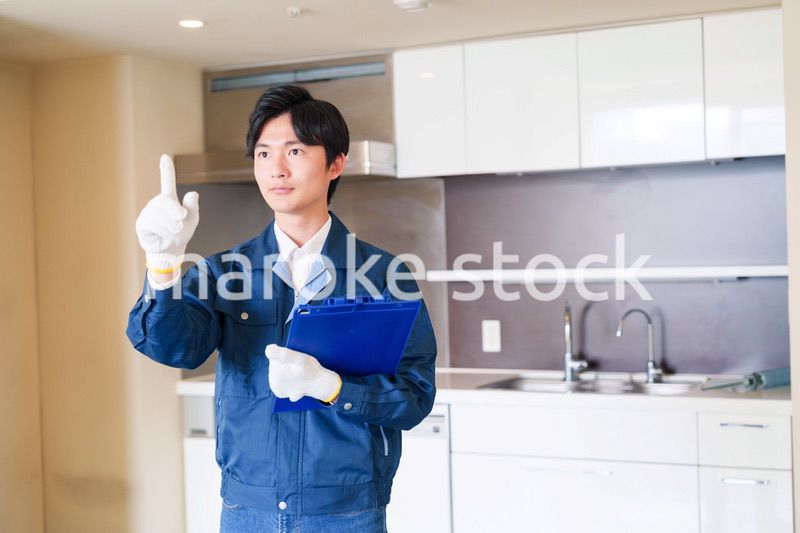 誠実な雰囲気でマンションの点検をする男性の作業員