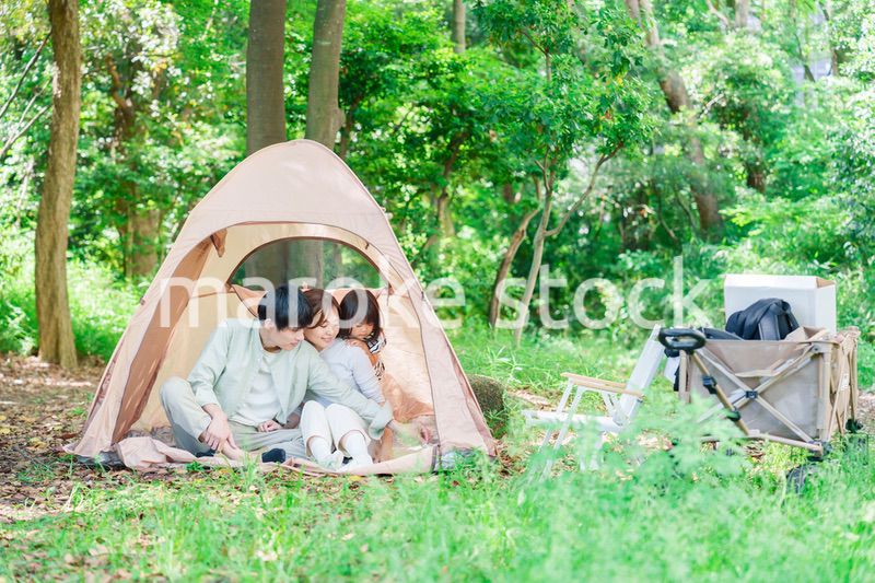 森の中でキャンプを楽しむ子供連れのファミリー