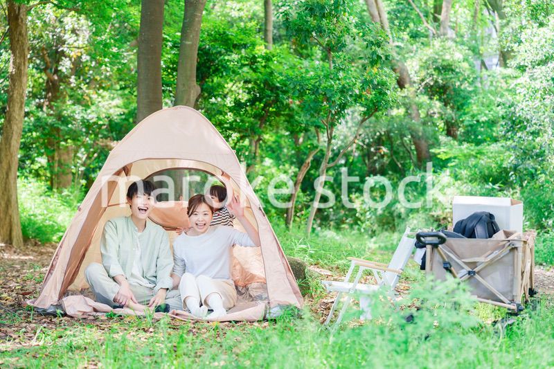 森の中でキャンプを楽しむ子供連れのファミリー