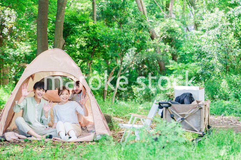 森の中でキャンプを楽しむ子供連れのファミリー