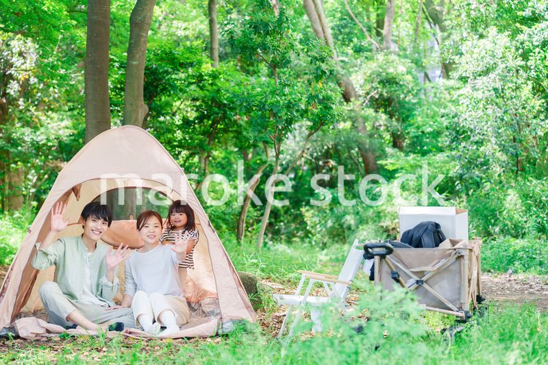 森の中でキャンプを楽しむ子供連れのファミリー
