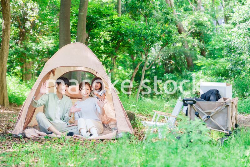 森の中でキャンプを楽しむ子供連れのファミリー