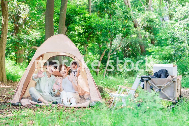 森の中でキャンプを楽しむ子供連れのファミリー