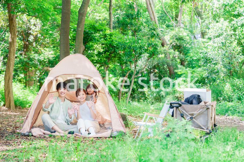 森の中でキャンプを楽しむ子供連れのファミリー