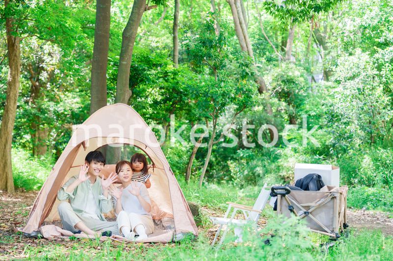 森の中でキャンプを楽しむ子供連れのファミリー