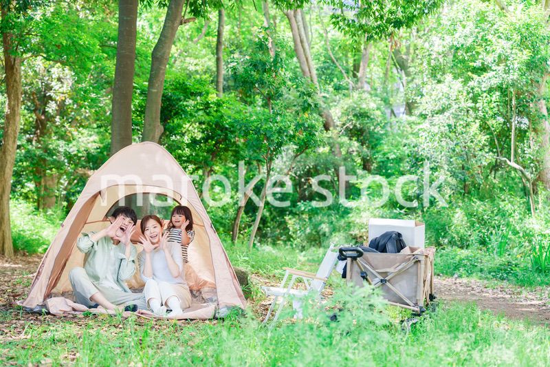 森の中でキャンプを楽しむ子供連れのファミリー