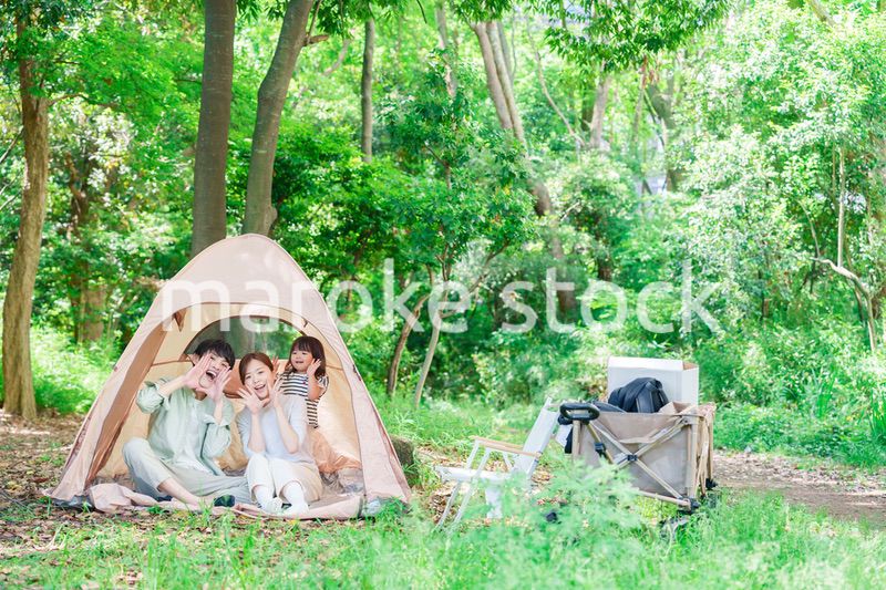 森の中でキャンプを楽しむ子供連れのファミリー