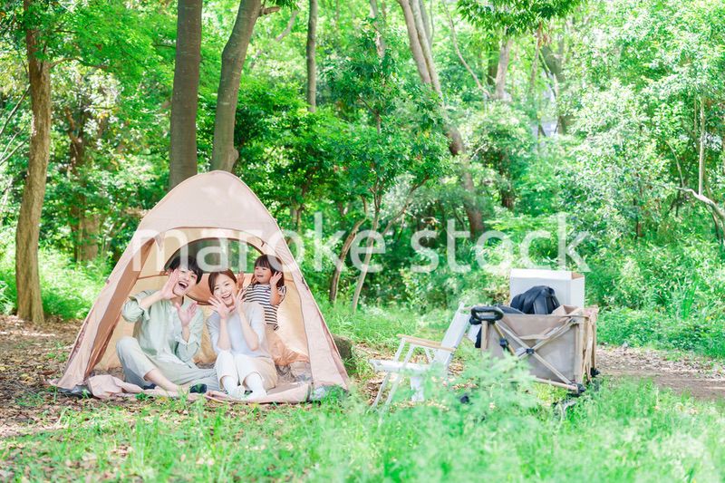 森の中でキャンプを楽しむ子供連れのファミリー