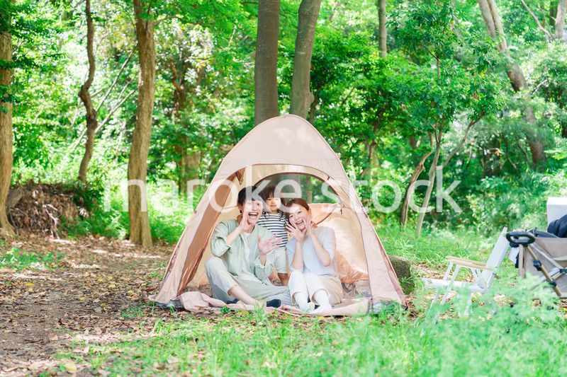 森の中でキャンプを楽しむ子供連れのファミリー