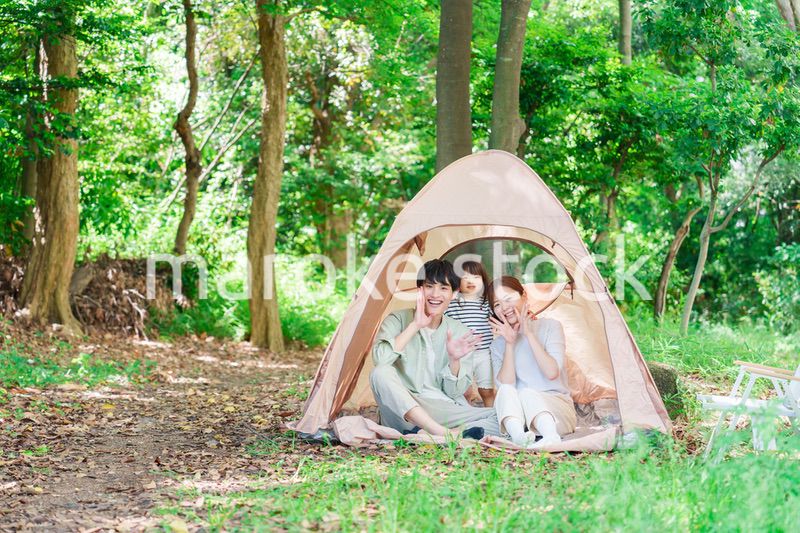 森の中でキャンプを楽しむ子供連れのファミリー
