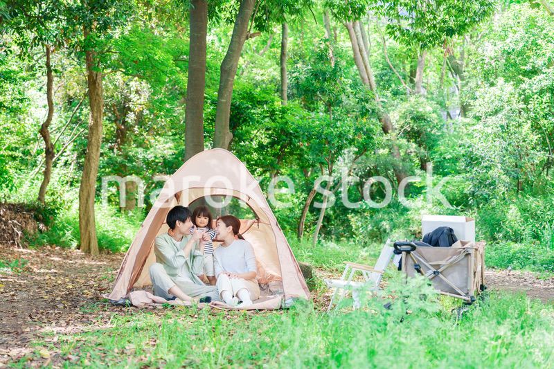 森の中でキャンプを楽しむ子供連れのファミリー