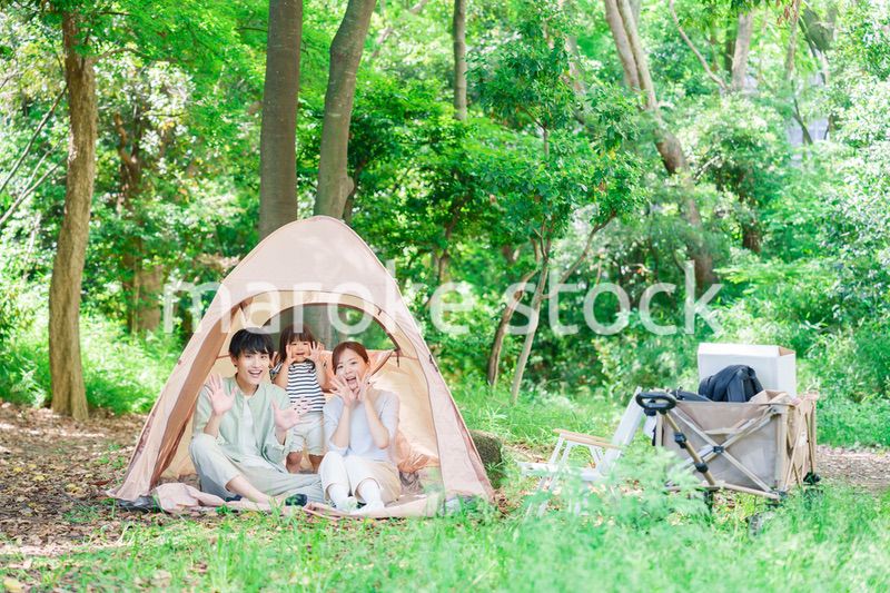 森の中でキャンプを楽しむ子供連れのファミリー