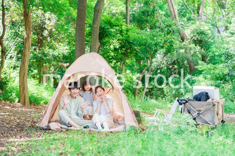 森の中でキャンプを楽しむ子供連れのファミリー