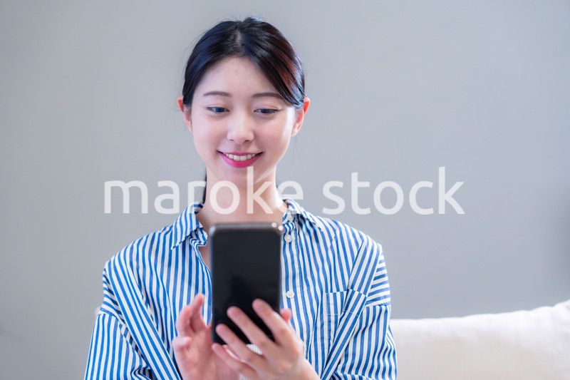 笑顔でスマホアプリを使う若い女性