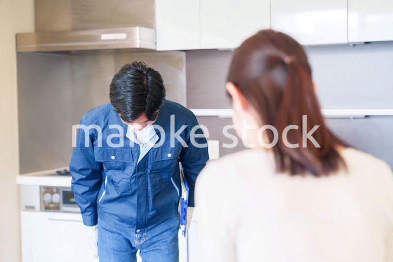 お客様に頭を下げてお詫びをする作業員の男性