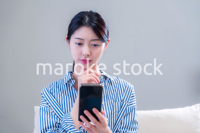 笑顔でスマホアプリを使う若い女性