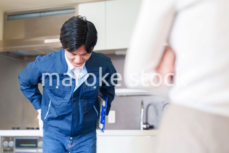お客様に頭を下げてお詫びをする作業員の男性