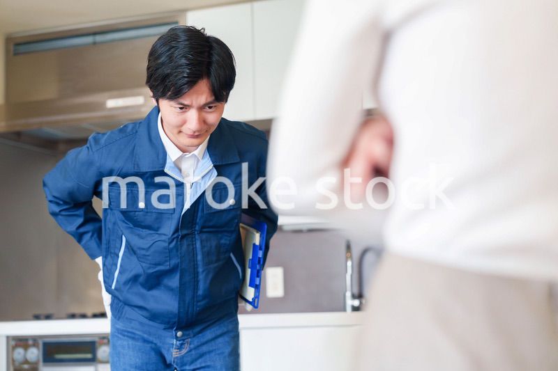 お客様に頭を下げてお詫びをする作業員の男性