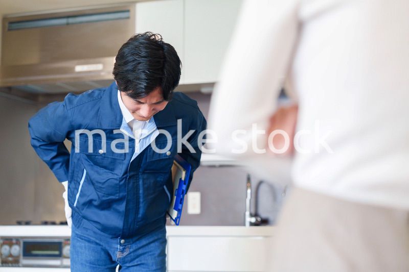 お客様に頭を下げてお詫びをする作業員の男性