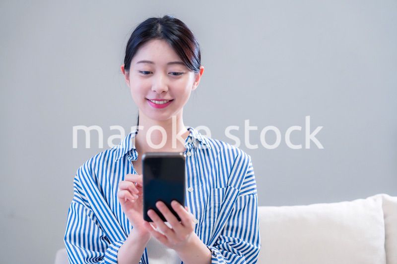 笑顔でスマホアプリを使う若い女性