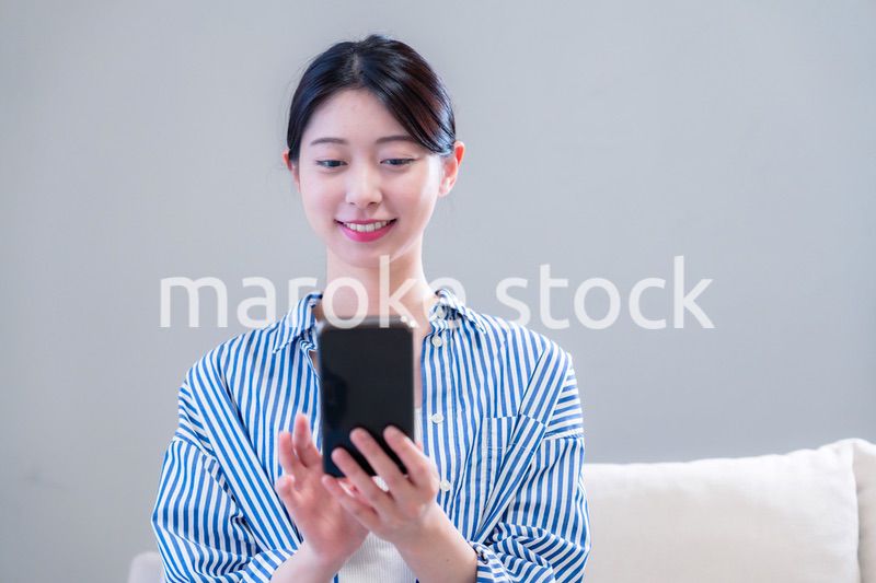 笑顔でスマホアプリを使う若い女性