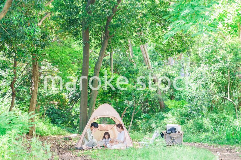 森の中でキャンプを楽しむ子供連れのファミリー