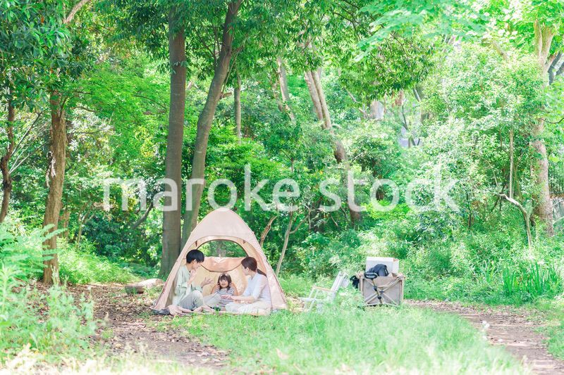 森の中でキャンプを楽しむ子供連れのファミリー