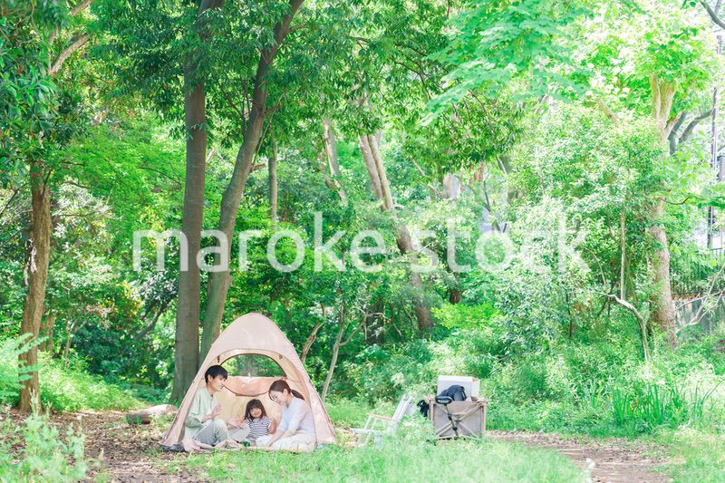 森の中でキャンプを楽しむ子供連れのファミリー