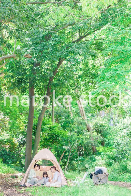 森の中でキャンプを楽しむ子供連れのファミリー