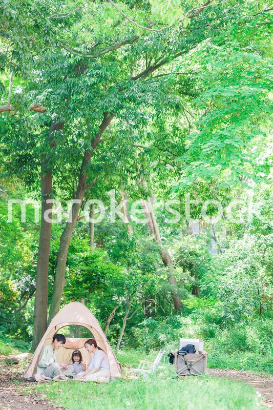 森の中でキャンプを楽しむ子供連れのファミリー