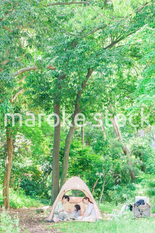 森の中でキャンプを楽しむ子供連れのファミリー