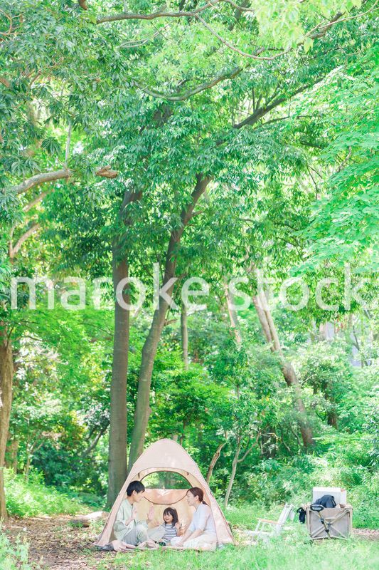 森の中でキャンプを楽しむ子供連れのファミリー