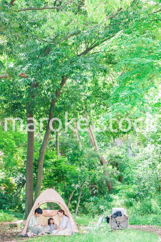 森の中でキャンプを楽しむ子供連れのファミリー