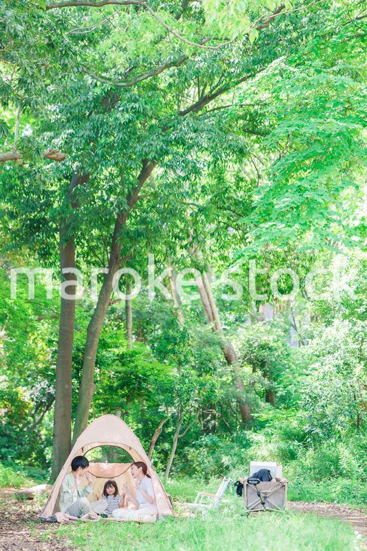 森の中でキャンプを楽しむ子供連れのファミリー