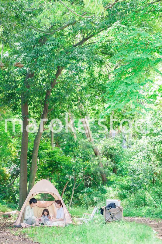 森の中でキャンプを楽しむ子供連れのファミリー