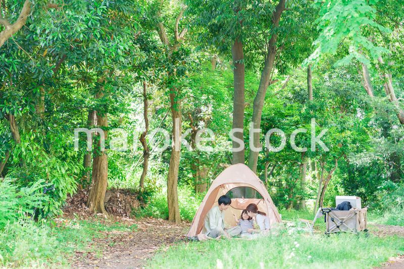 森の中でキャンプを楽しむ子供連れのファミリー