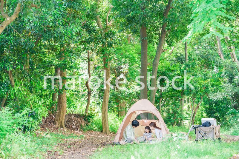 森の中でキャンプを楽しむ子供連れのファミリー