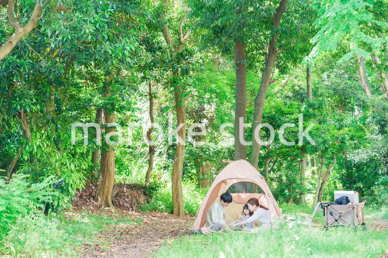 森の中でキャンプを楽しむ子供連れのファミリー