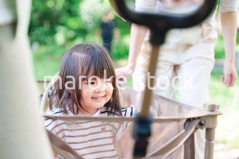 カートに乗って喜ぶ小さな女の子